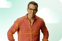 Portrait of actor Ryan Reynolds smiling against a mint-green background.